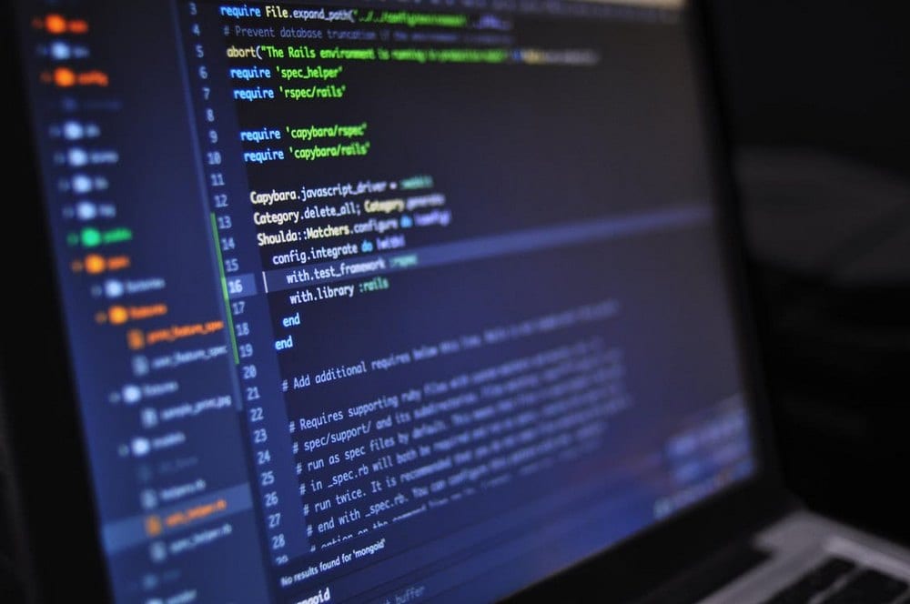Code editor on a laptop representing enterprise software delivery.
